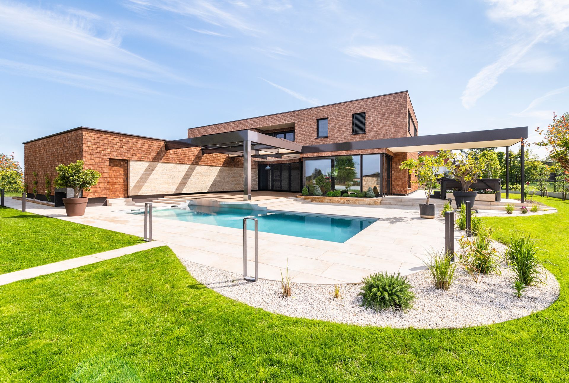 Ein modernes Haus mit einem großen Swimmingpool im Hinterhof.