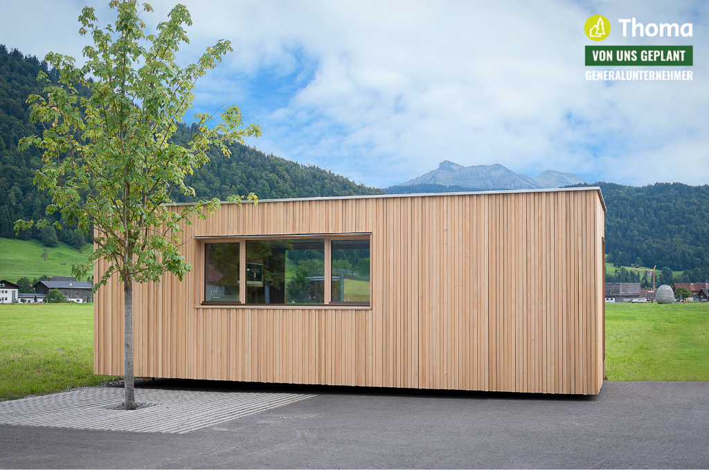 Ein kleines Holzhaus mit einem Baum davor