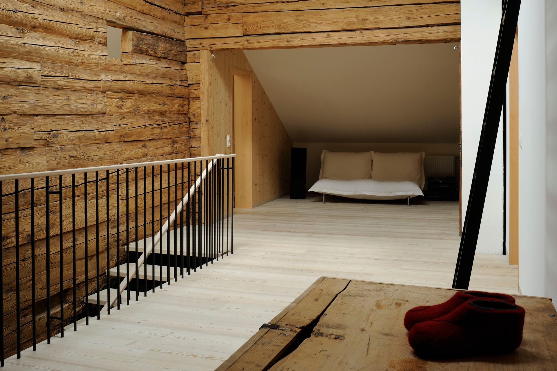 Eine Holztreppe führt zu einem Schlafzimmer mit einem Bett
