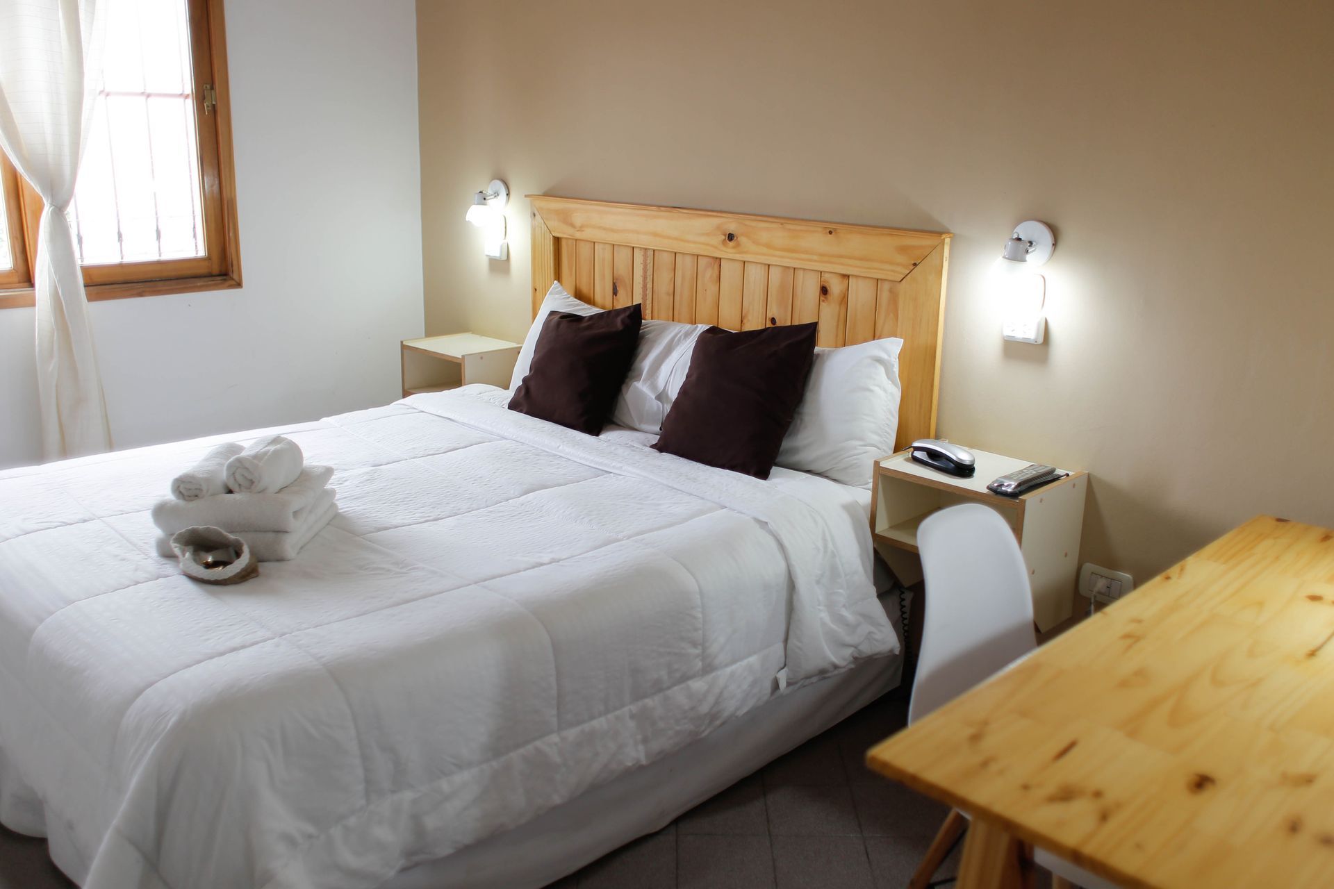 Un dormitorio con una cama grande y una mesa de madera