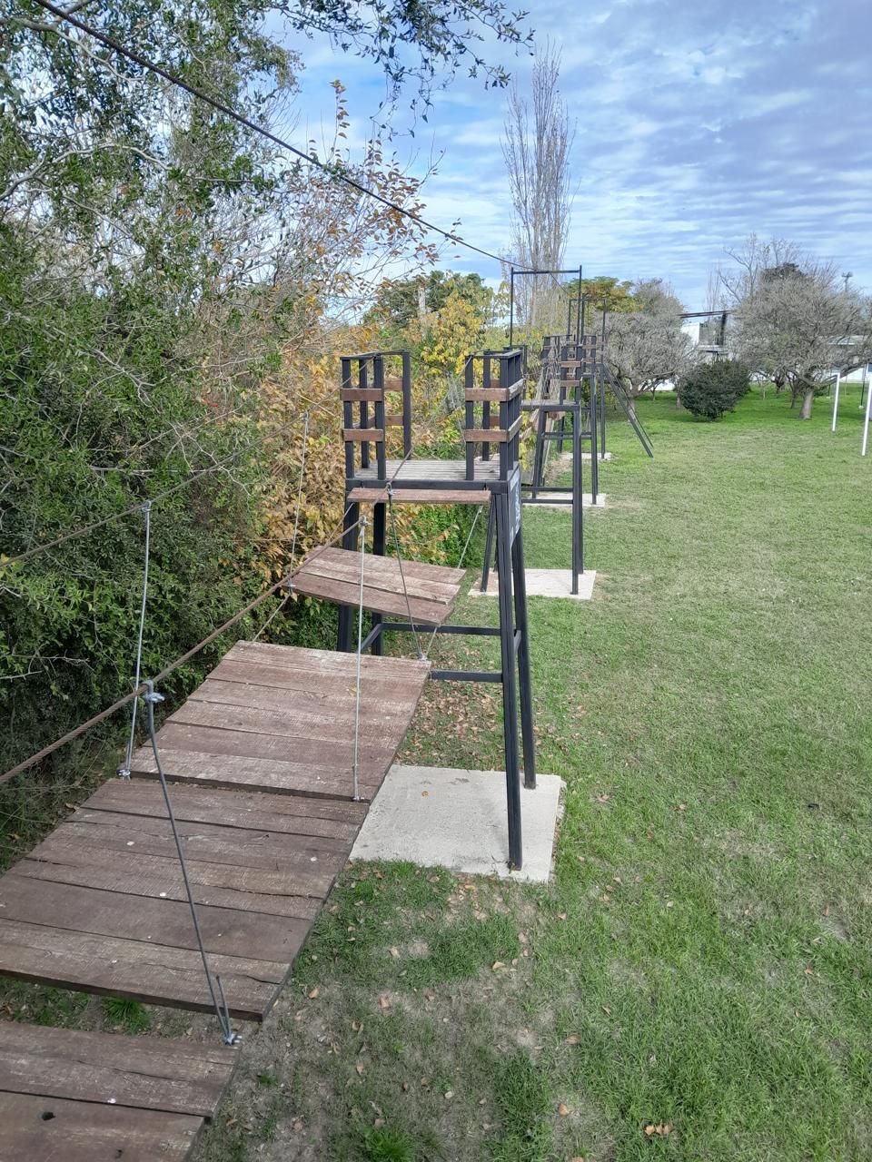 Una fila de sillas sentadas encima de una plataforma de madera en un parque.