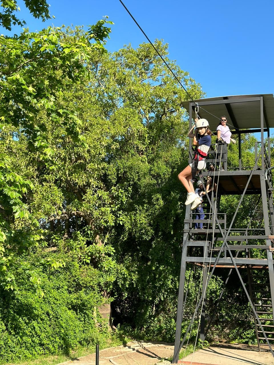 Una persona está montando una tirolesa en el bosque
