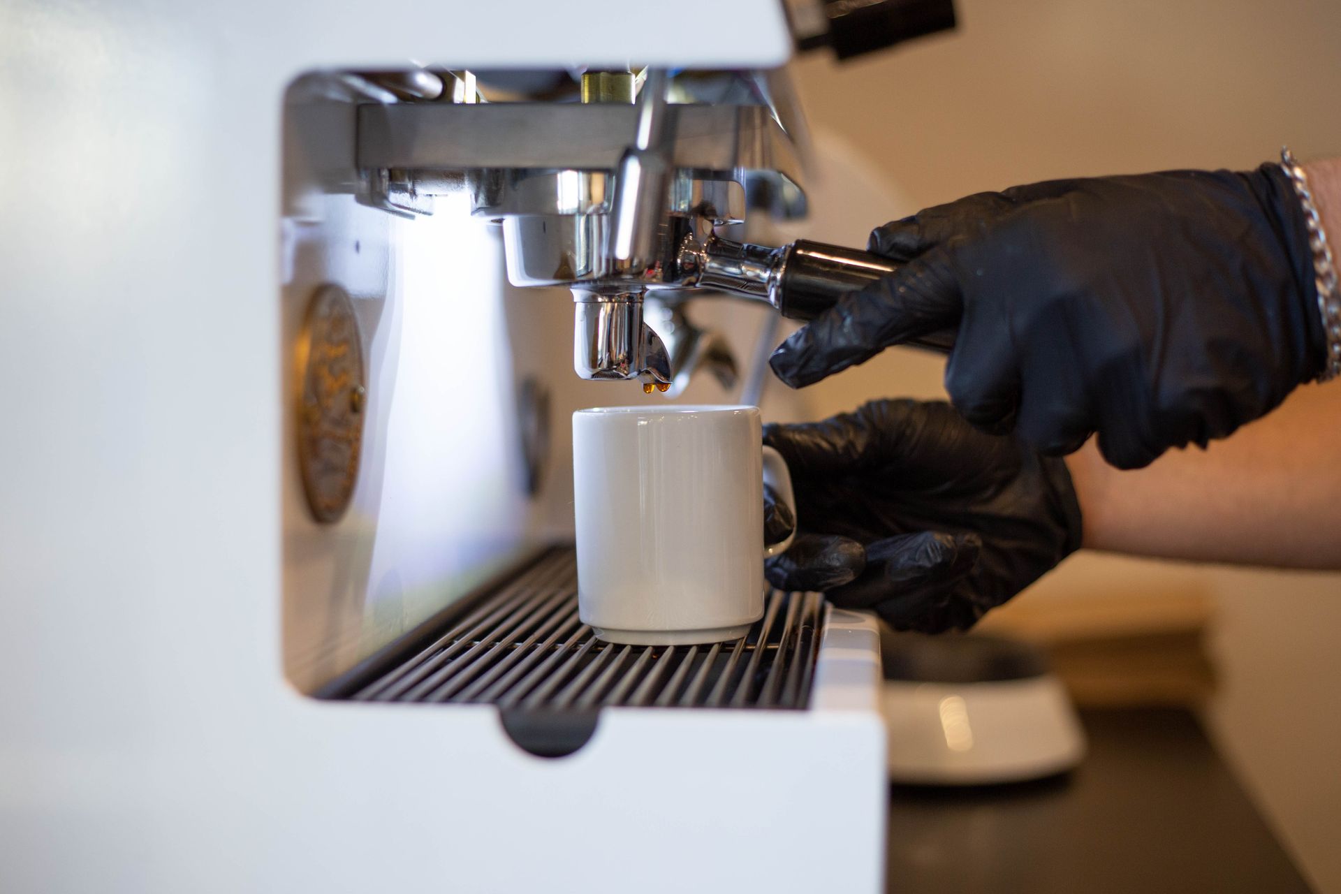 Una persona está preparando una taza de café en una cafetera.