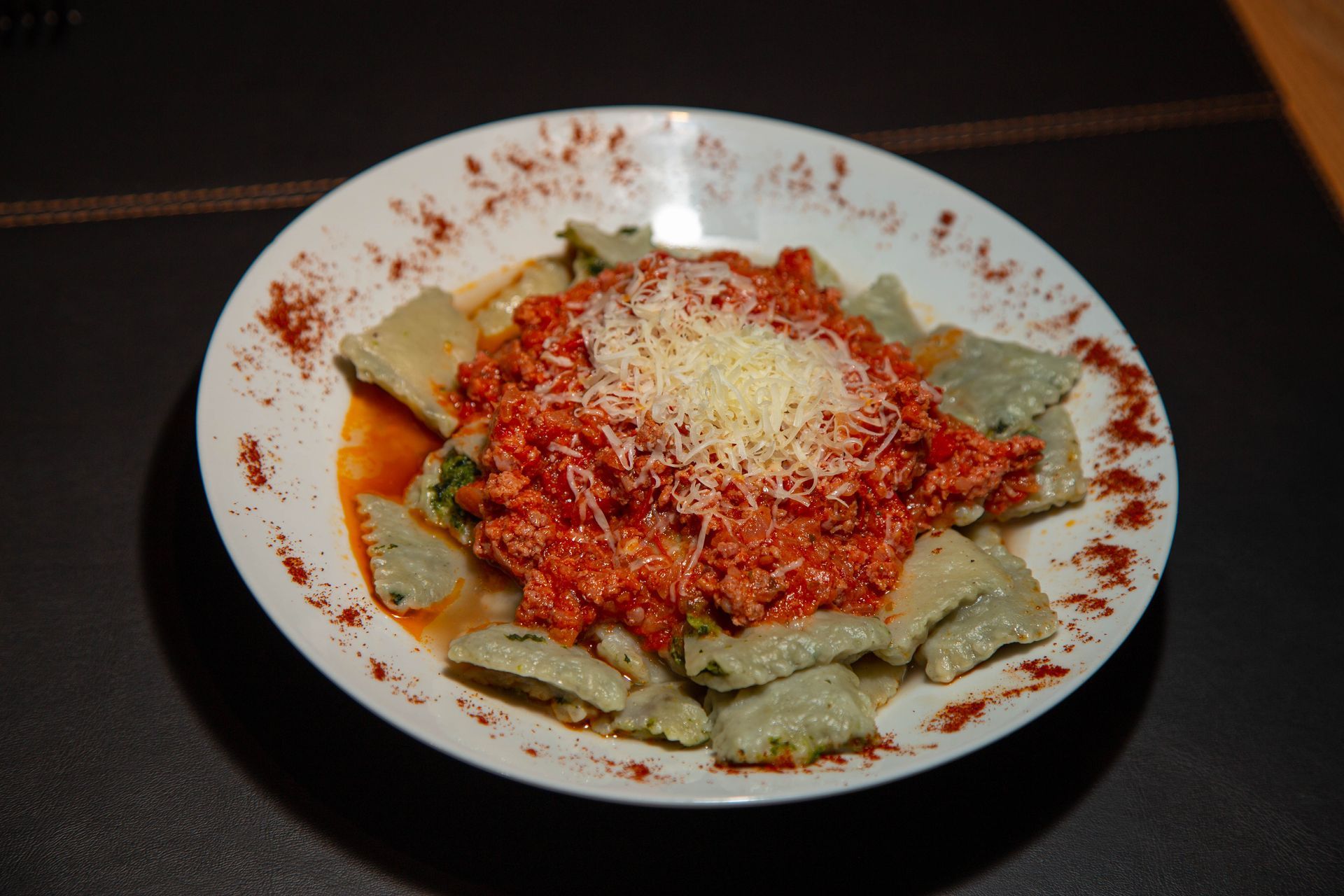 Un plato blanco cubierto con pasta y salsa sobre una mesa.