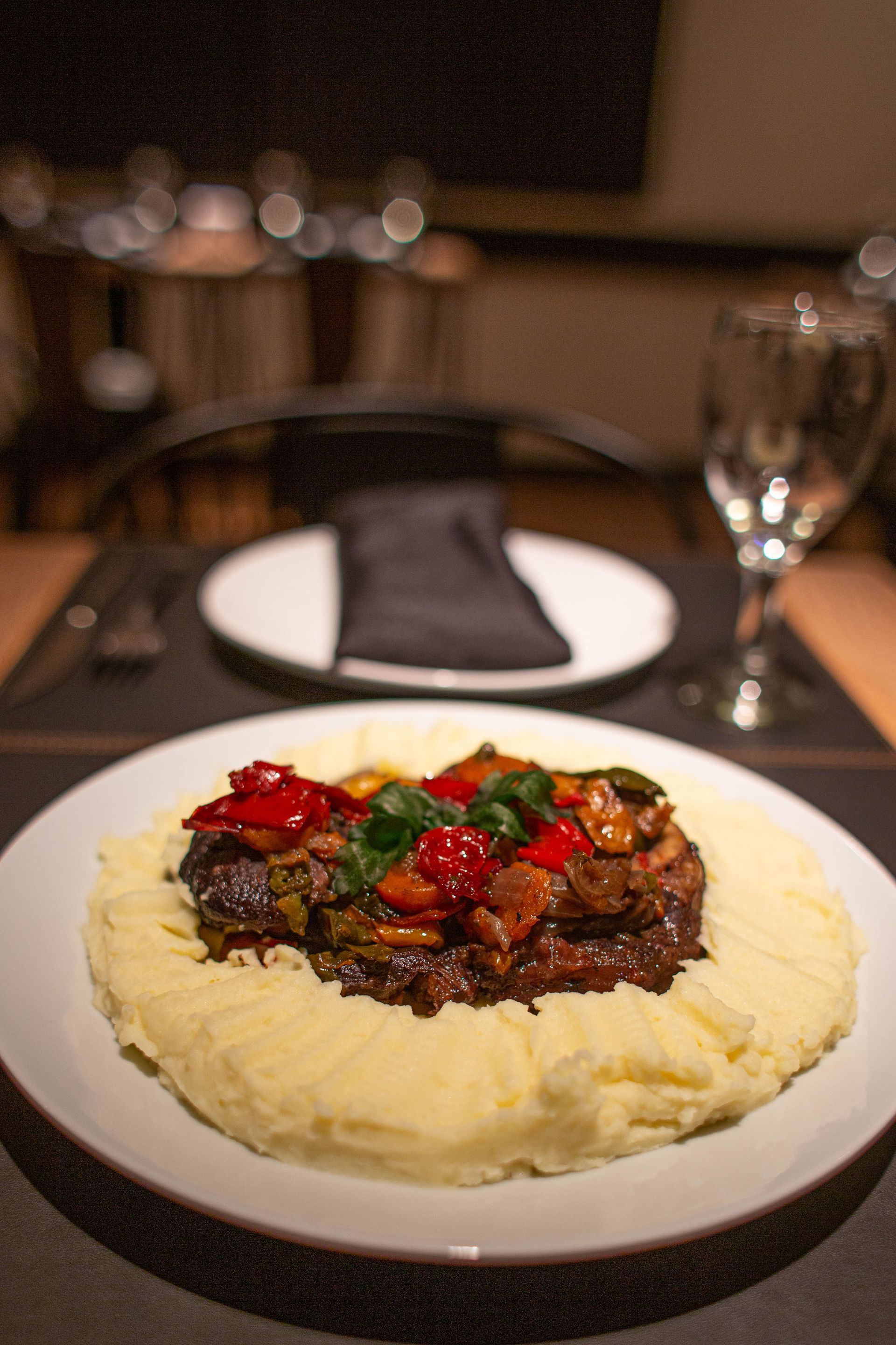 Un plato de comida con puré de patatas y verduras sobre una mesa.