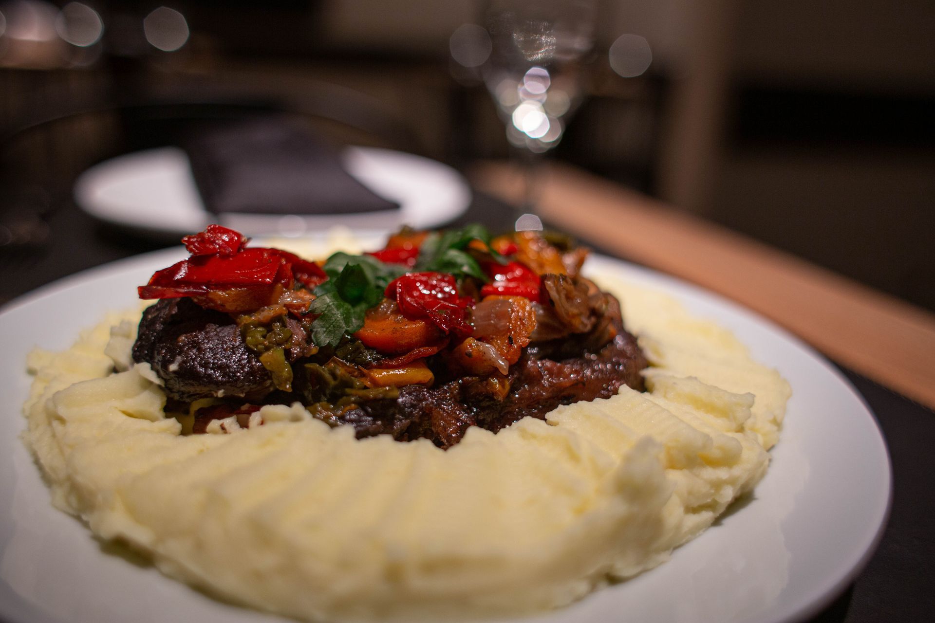 Un plato de comida con puré de patatas y verduras sobre una mesa.