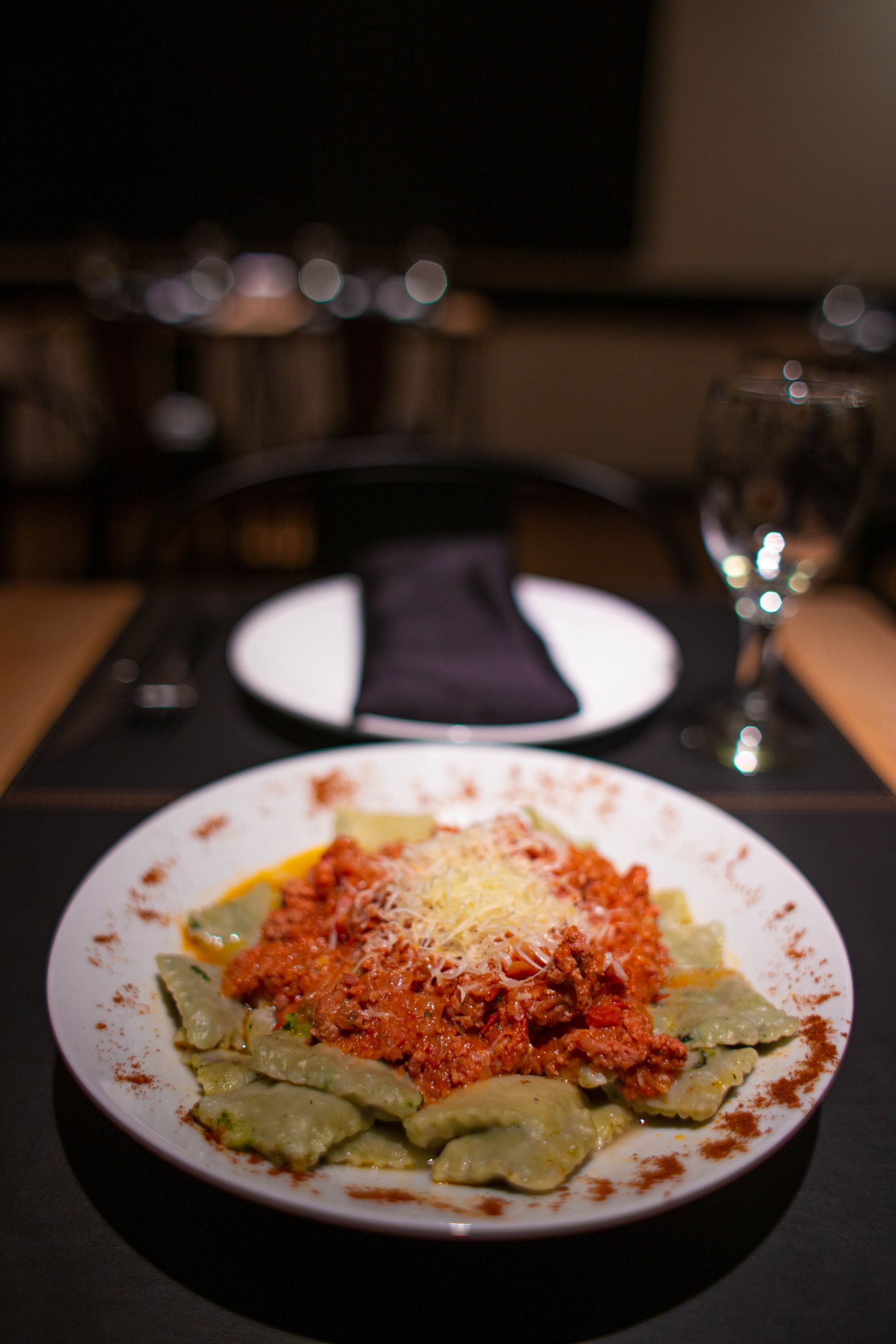Un plato de pasta con salsa de tomate y queso sobre una mesa.