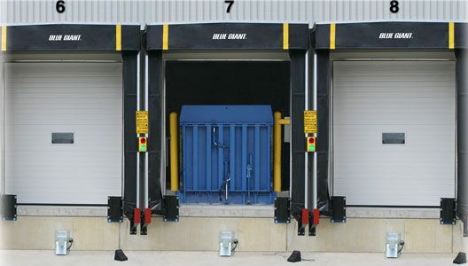 A blue container is being loaded into a warehouse