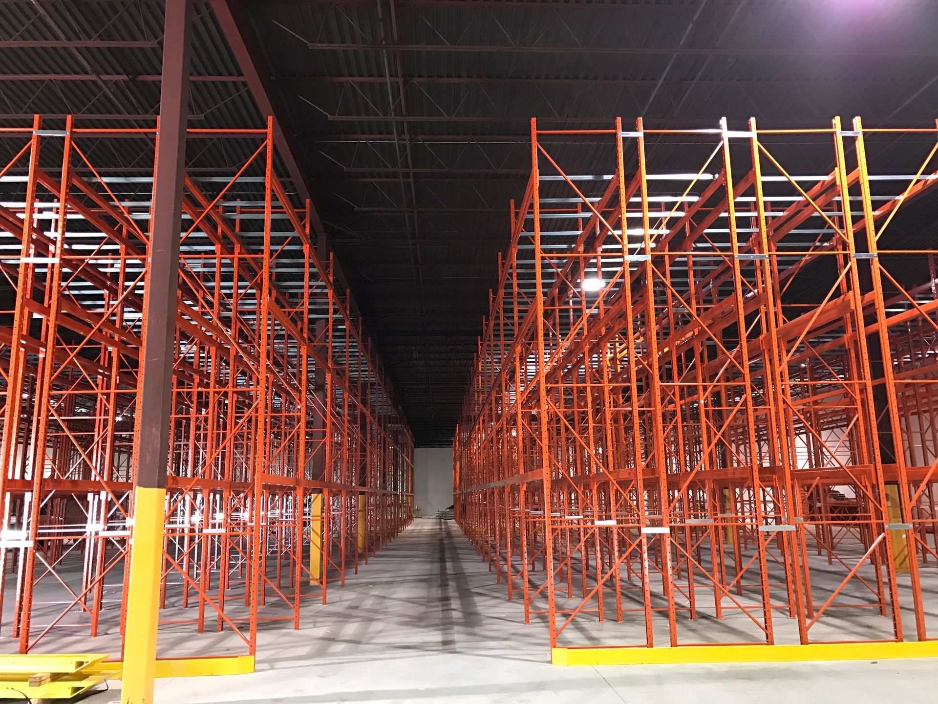 A large warehouse filled with lots of red shelves