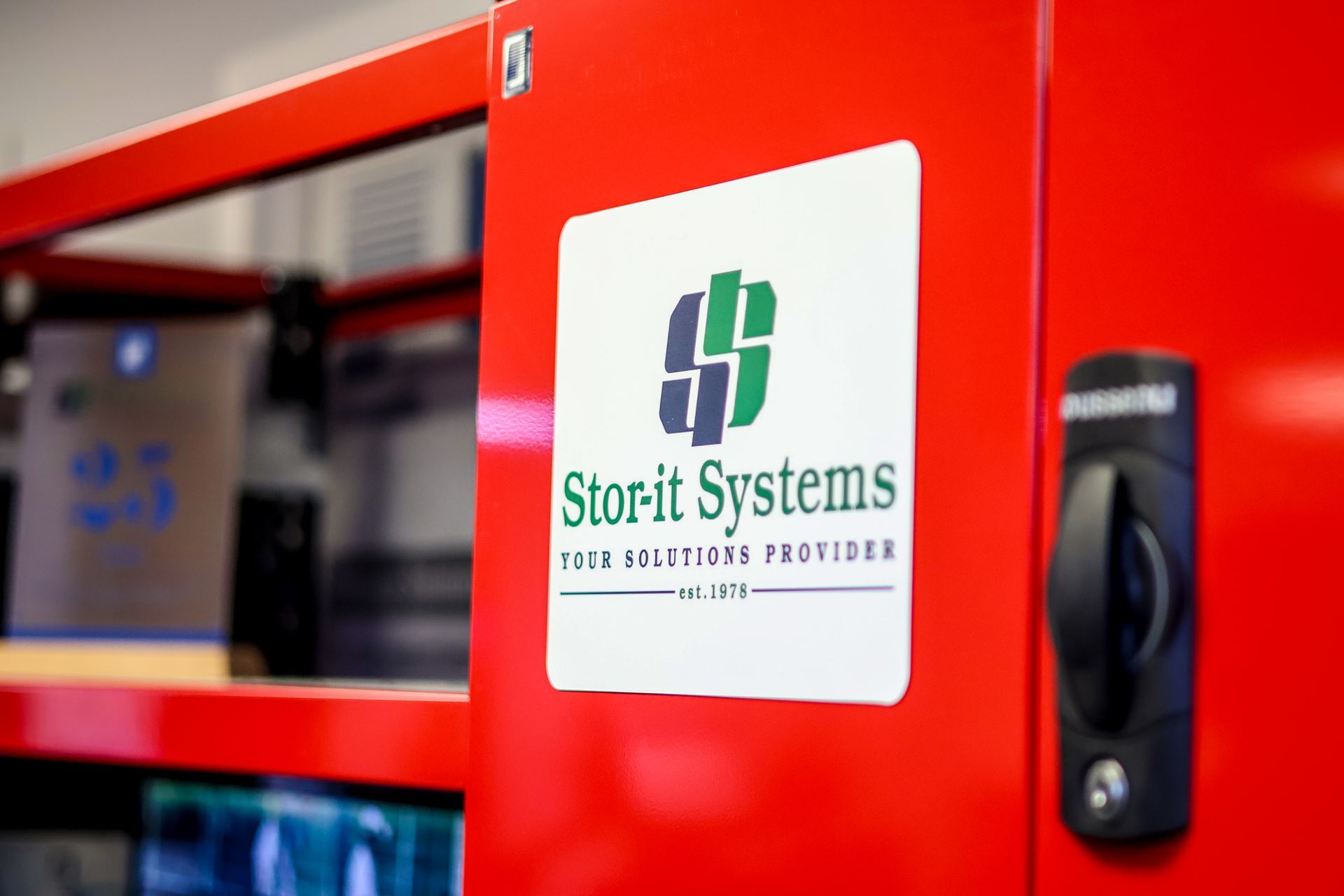 A red box with a sticker on it that says storit systems
