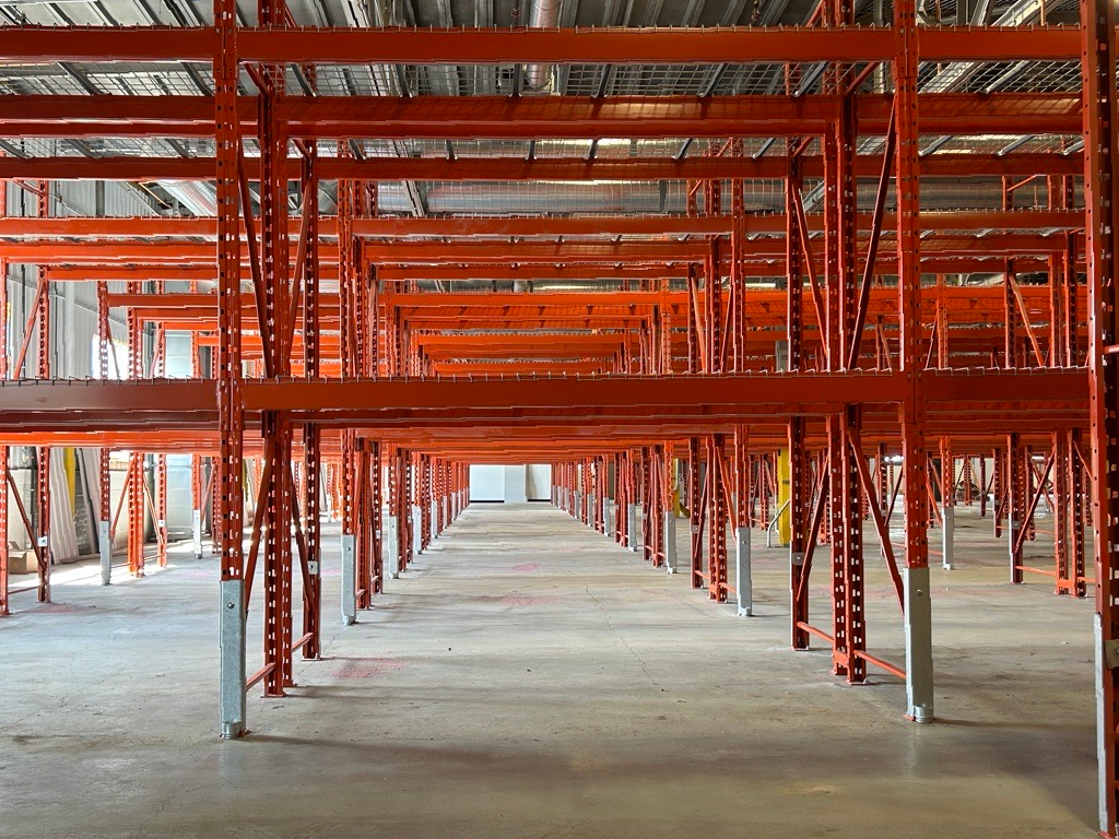An empty warehouse with a lot of orange shelves