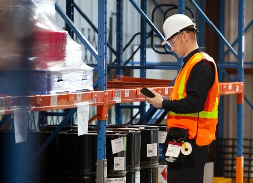 A warehouse filled with lots of shelves and red barriers.