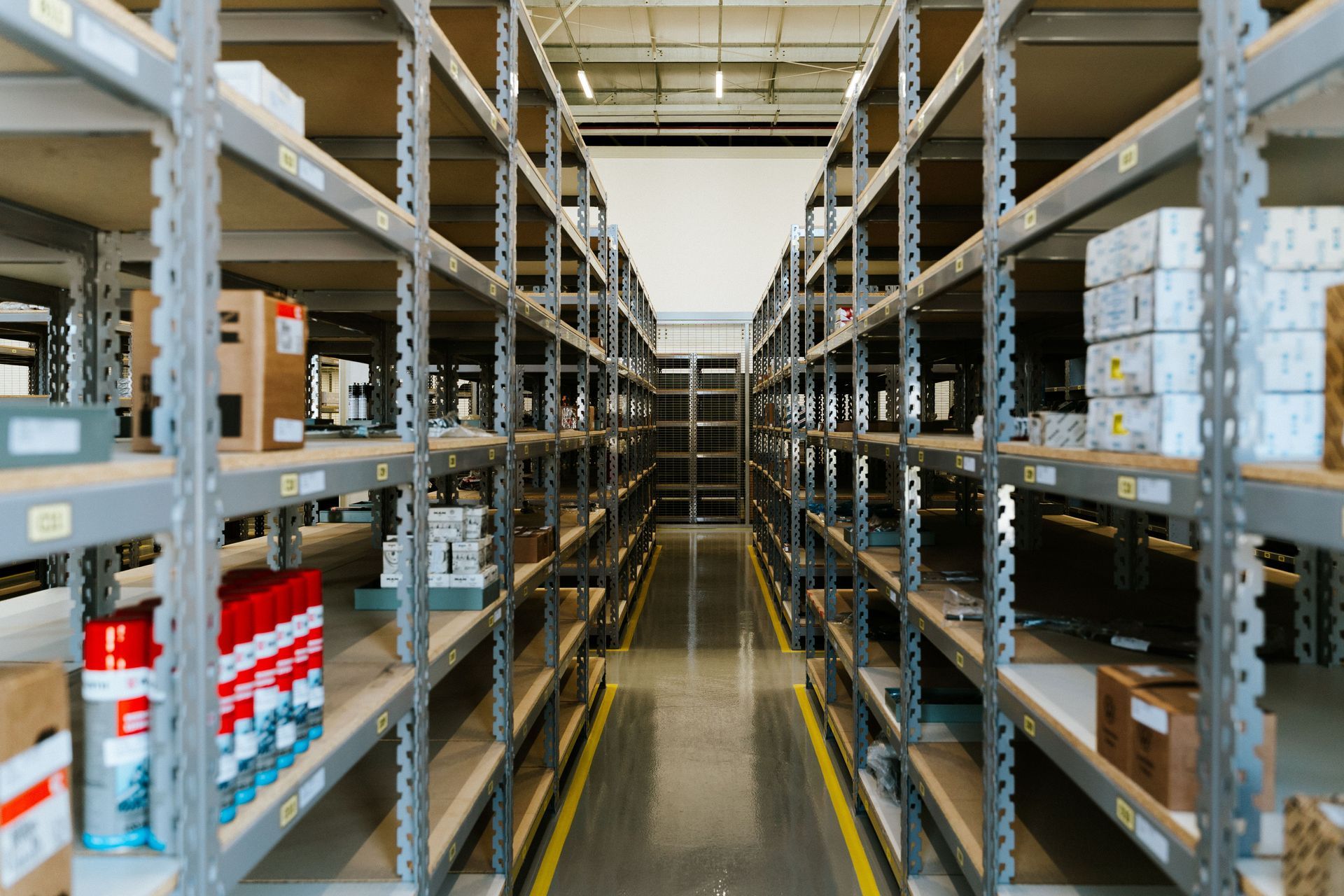 Stor-it Systems Aisle in a warehouse with tall metal shelves stocked with boxes and supplies