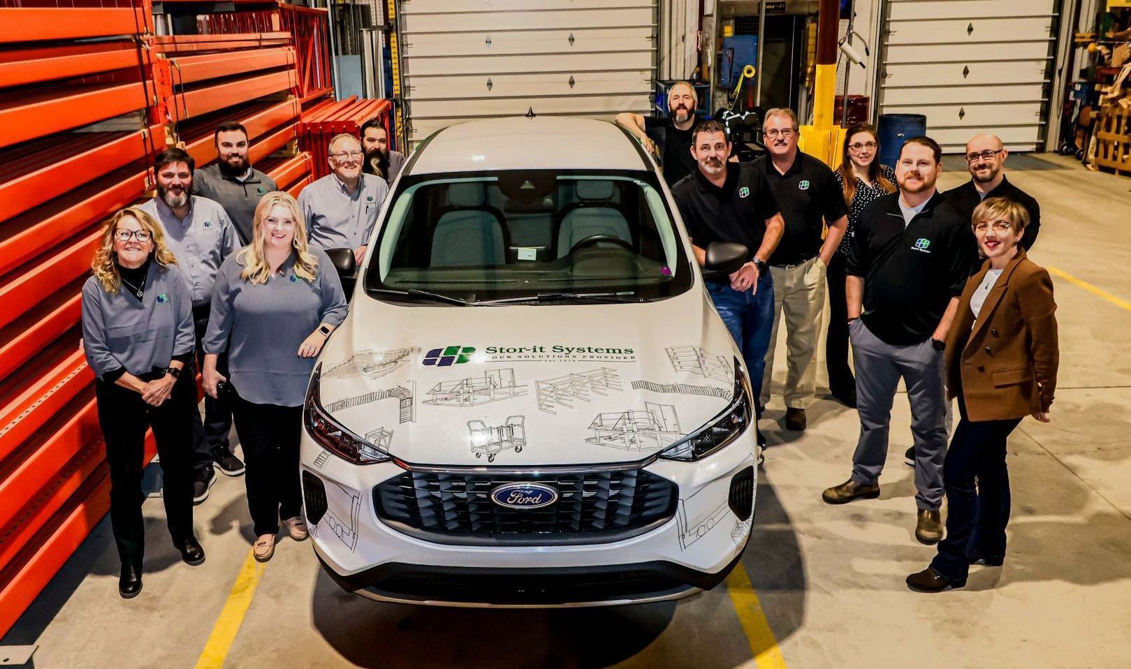A group of people are posing for a picture in front of a white car.