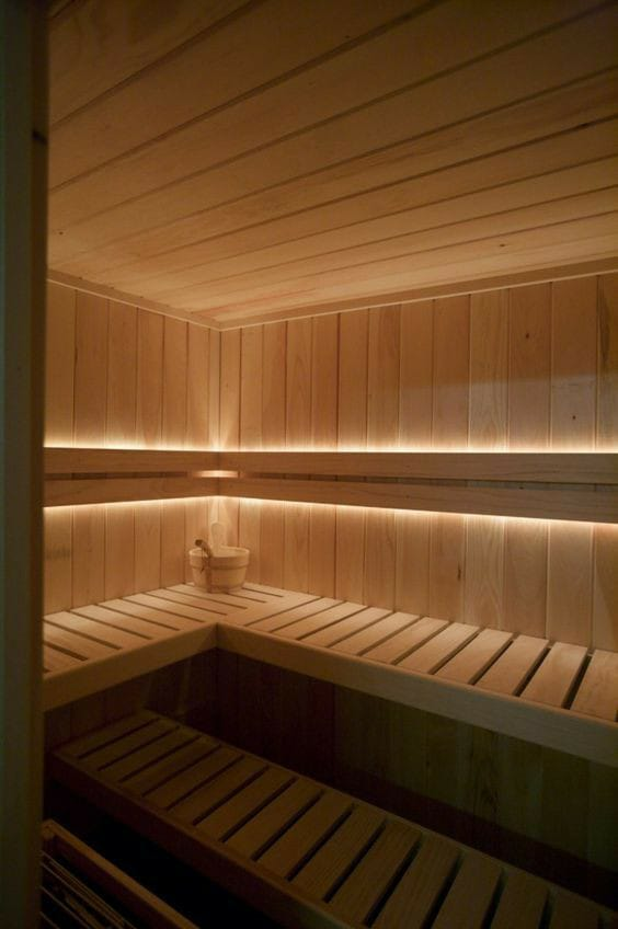 Una sauna de madera con luces en las paredes.