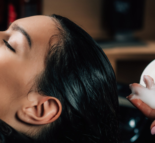 a woman smiling and straightening her hair