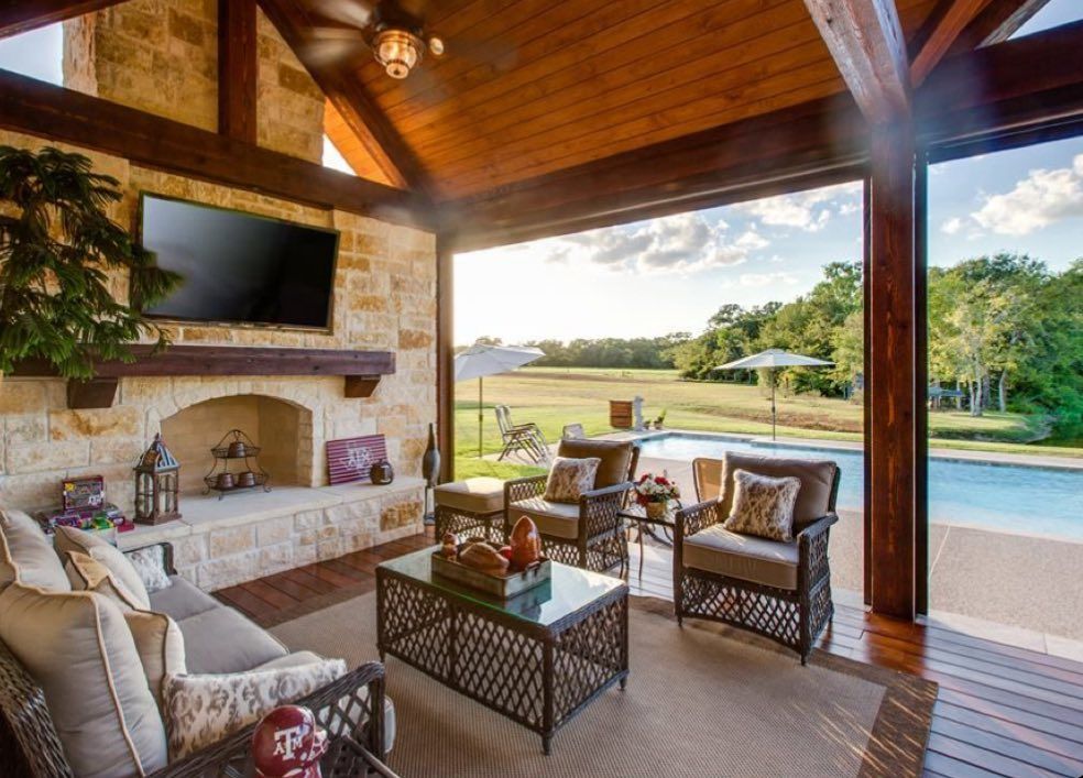 A person holding a baby up in the air indoors near a window, baby smiling.