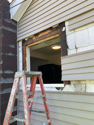 A ladder is leaning against the side of a house.