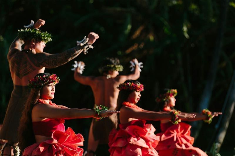 A group of people in red dresses are dancing in a line.