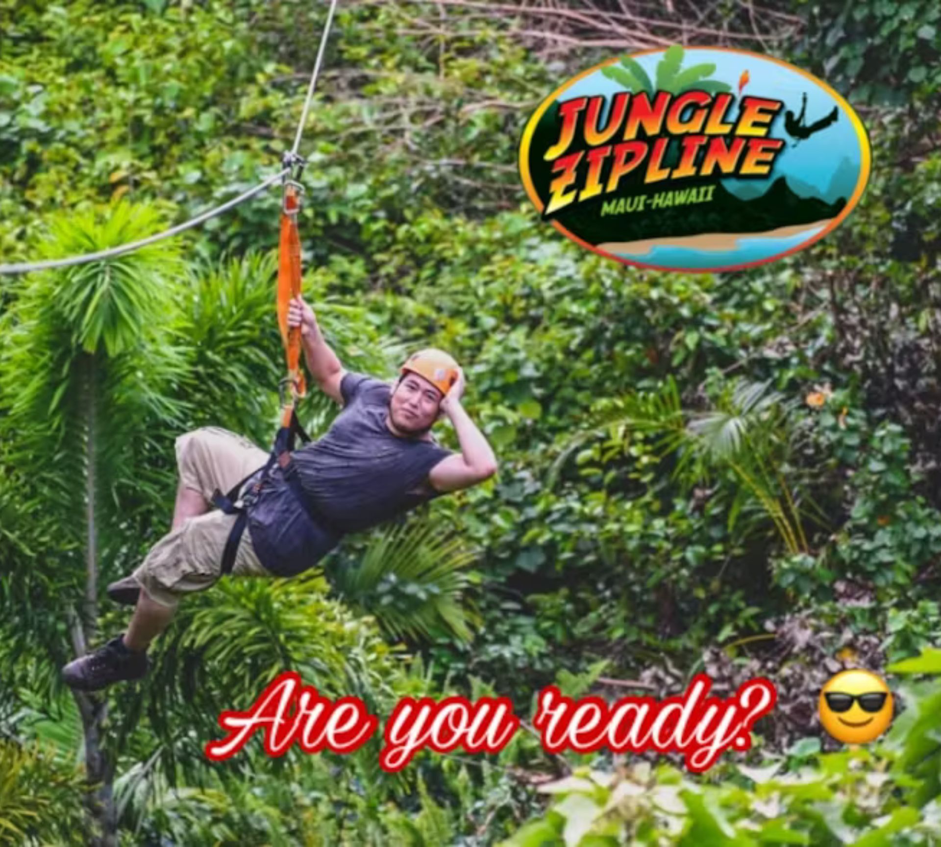 A man is flying through the air on a jungle zipline