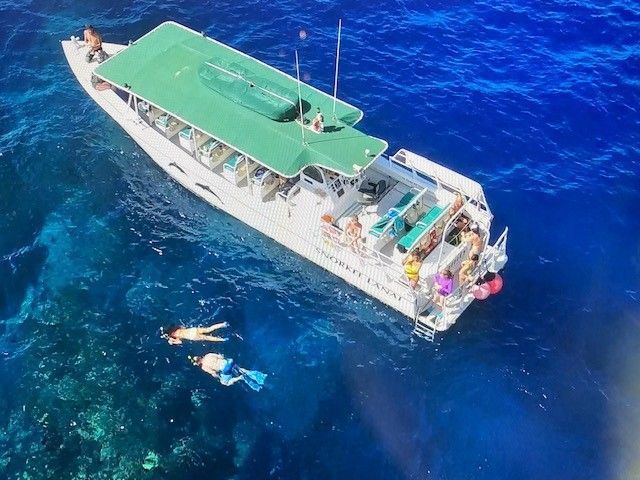 A boat with people on it is floating in the ocean.