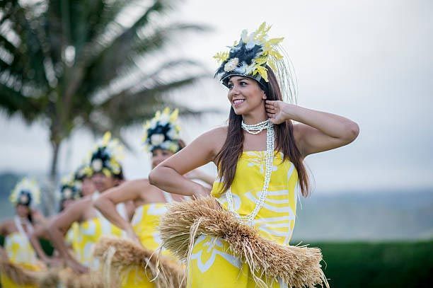 A group of women are dancing a hula on a beach.