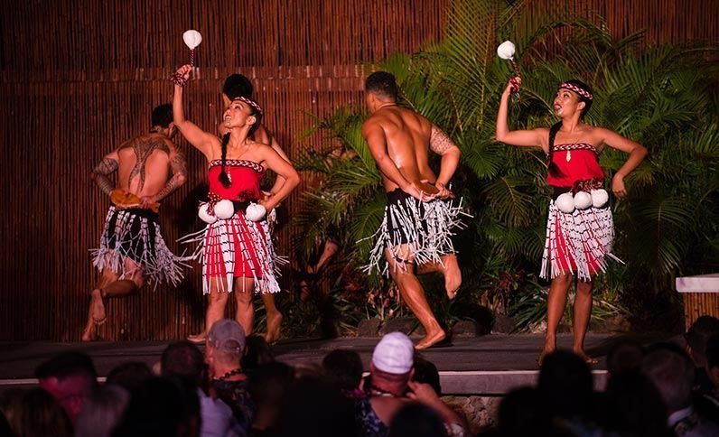A group of people are dancing on a stage in front of a crowd.