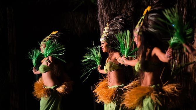 A group of women are dancing in a dark room.