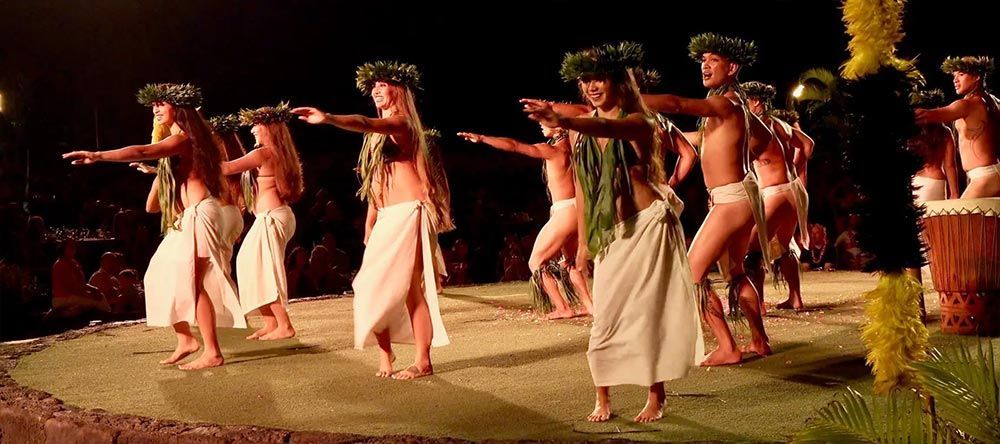 A group of people are dancing on a stage at night.