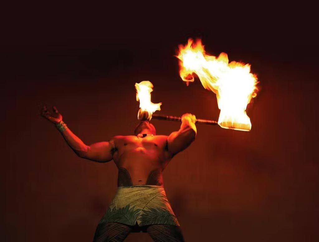 A man is holding a torch with flames coming out of it.