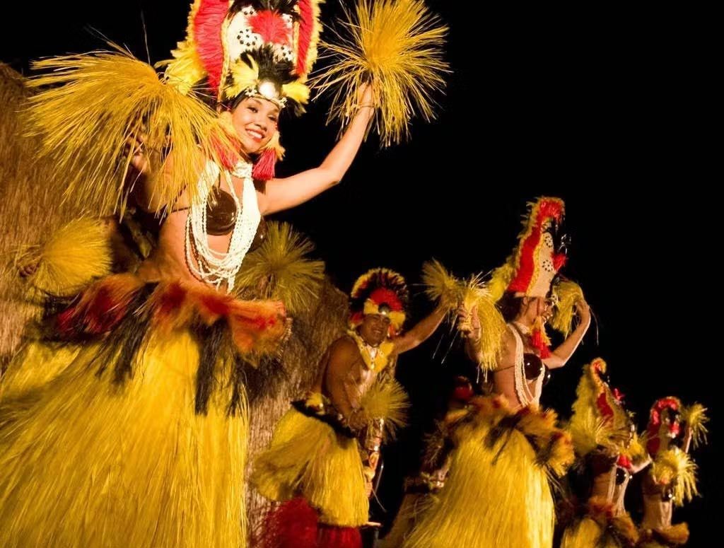 A group of people are dancing in a line in a dark room.