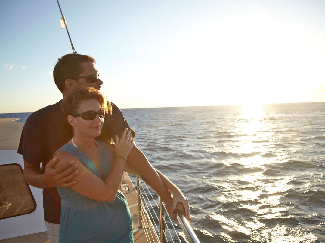 A boat with people on it is floating in the ocean.