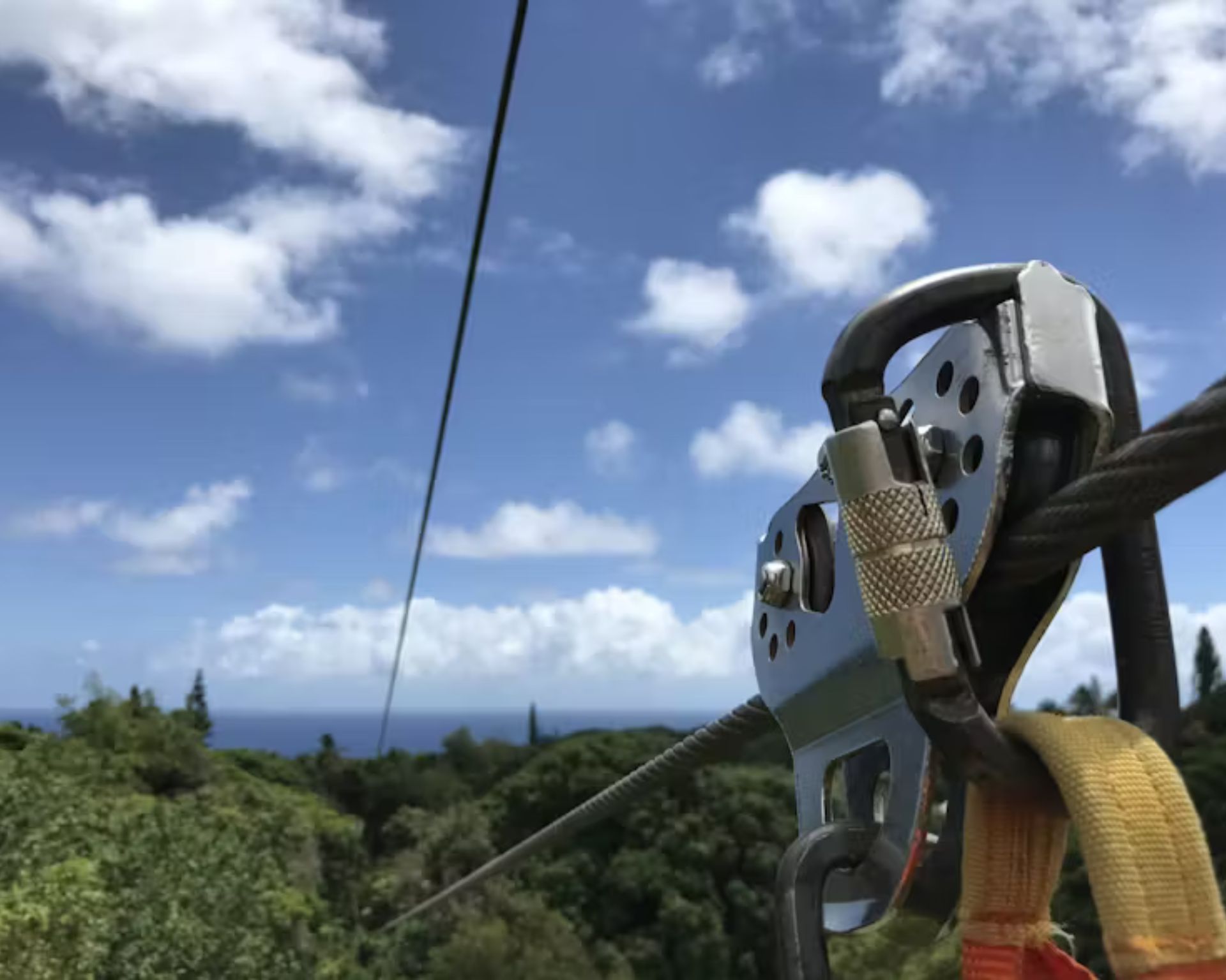 A close up of a zip line with a blue sky in the background