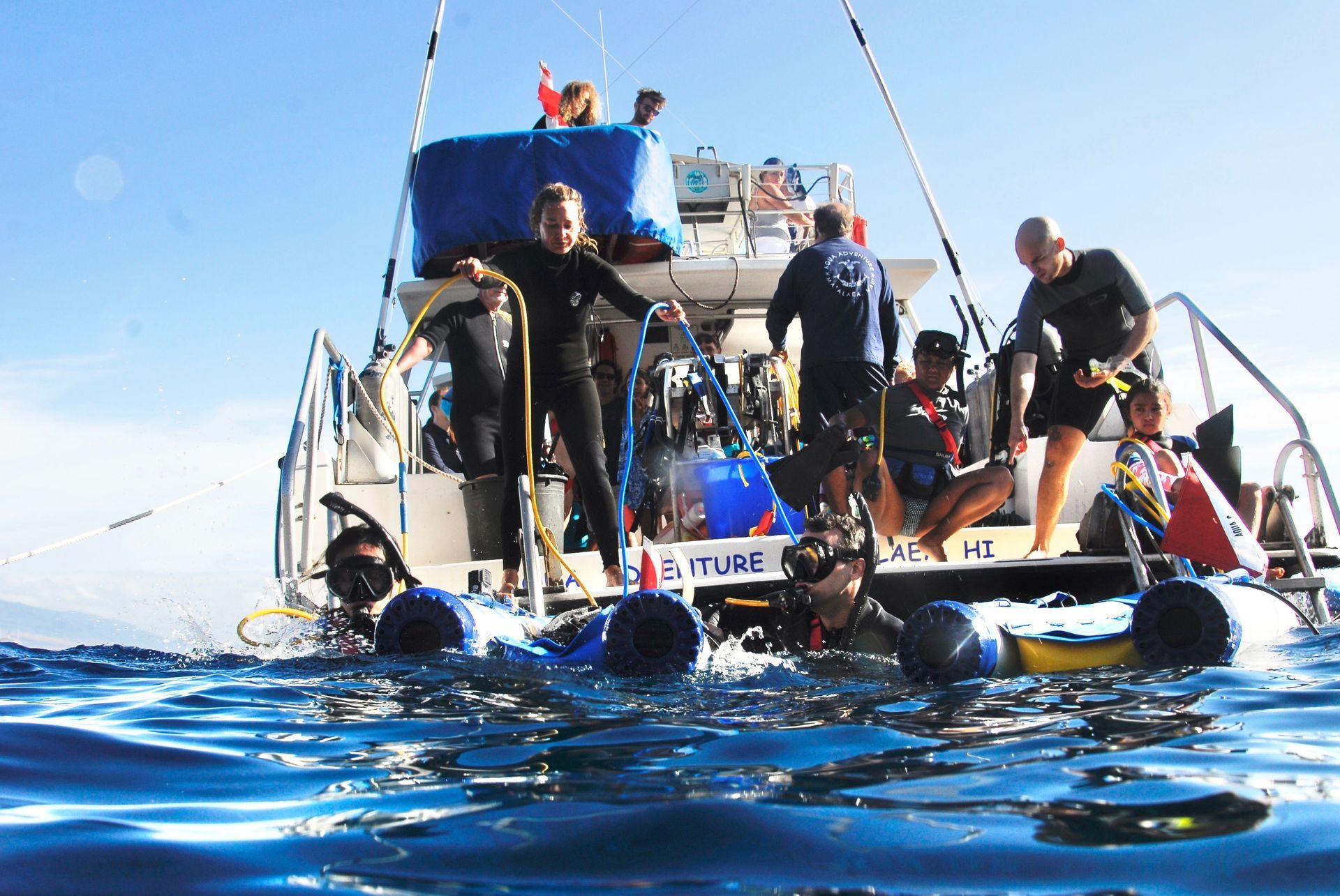 A group of people standing on top of a boat in the ocean