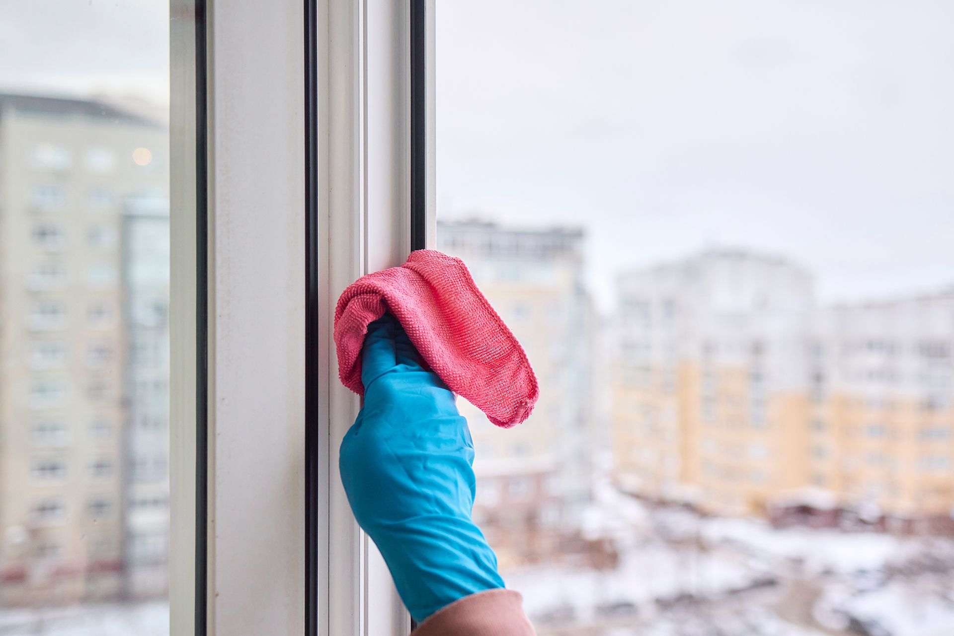 A person is cleaning a window with a cloth.