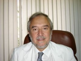 Un hombre con bata blanca y corbata está sentado en una silla.