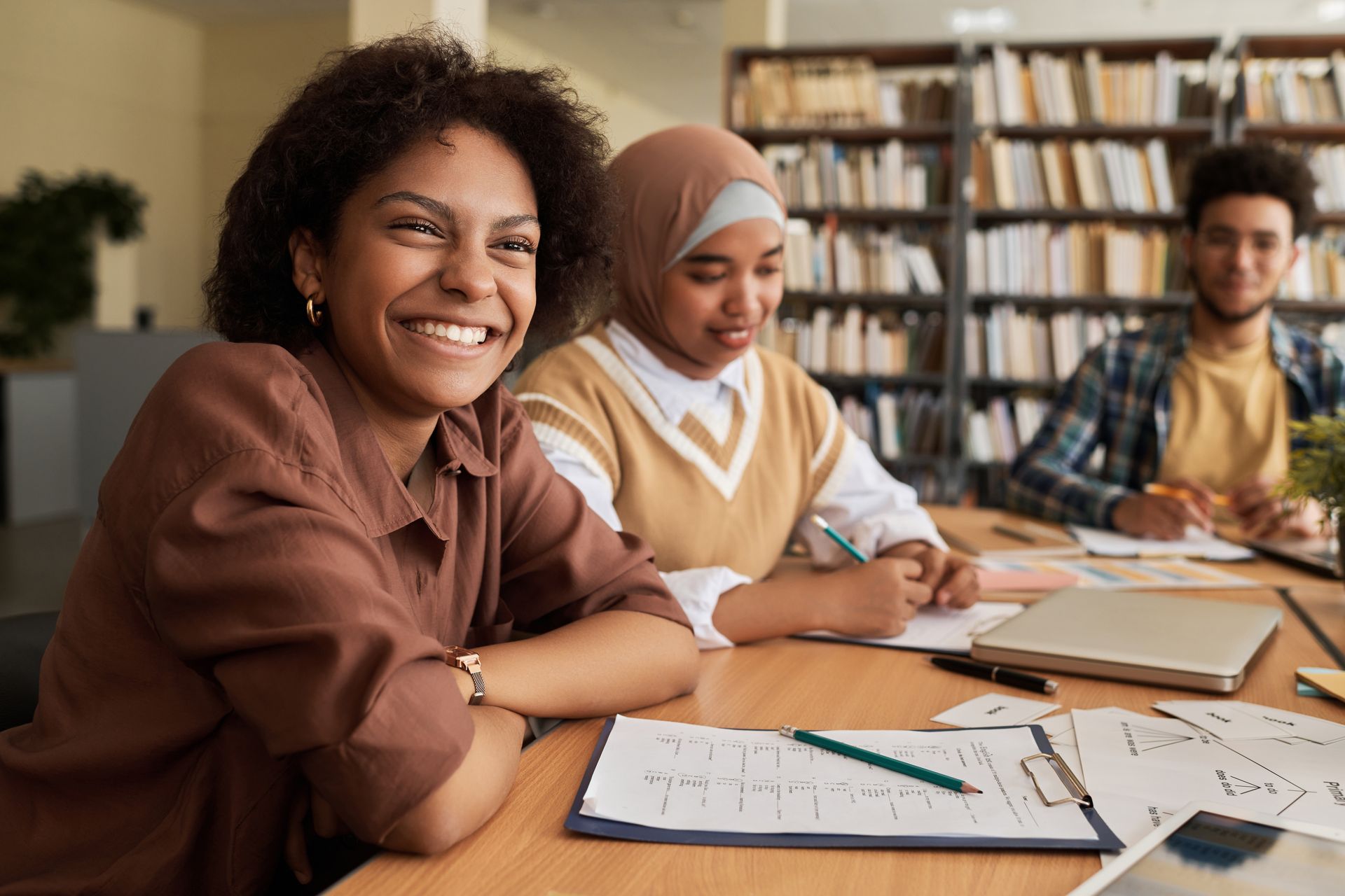 A group of people are sitting at a table in a library.
