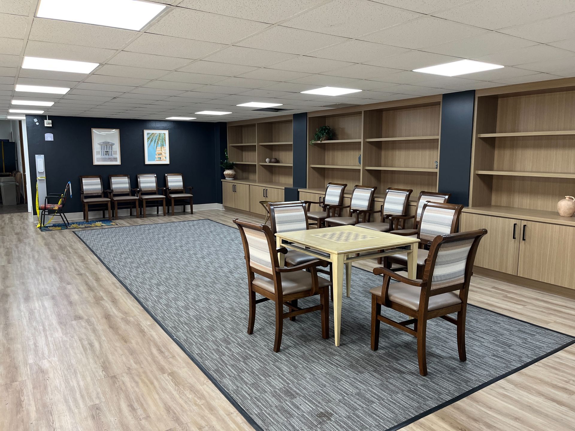 Accessible kitchen: white cabinets, appliances. Sink and cooktop are at lowered heights. Light wood flooring.