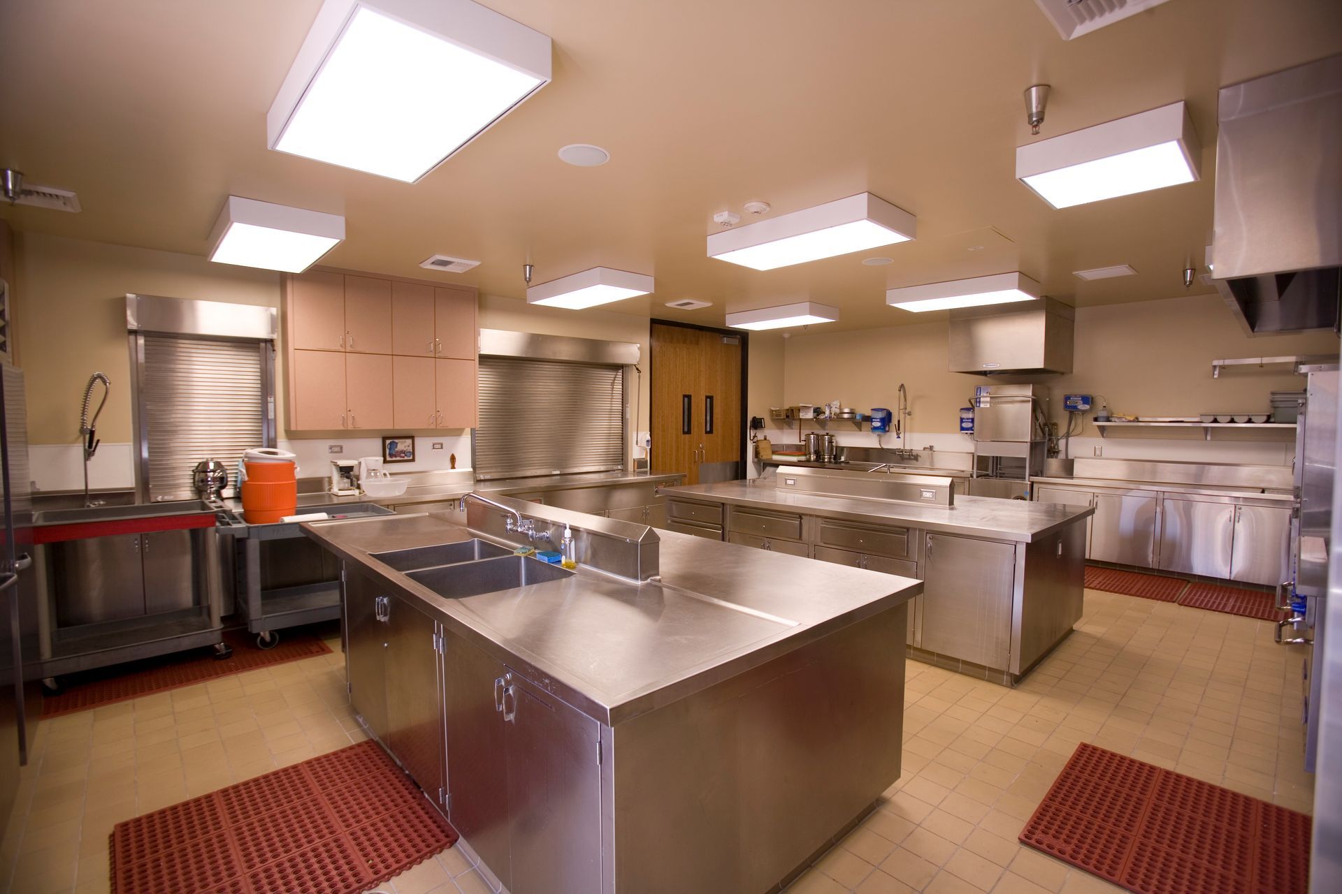 Commercial kitchen with stainless steel counters, cabinets, and appliances.