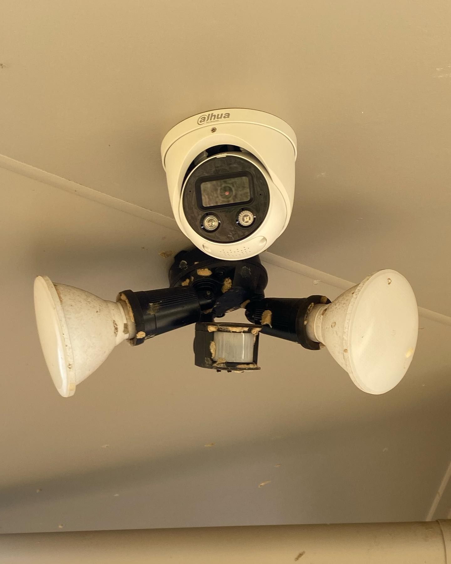A Security Camera Hanging From the Ceiling With Two Lights Attached to It — DGC Tech Solutions In Port Douglas, QLD