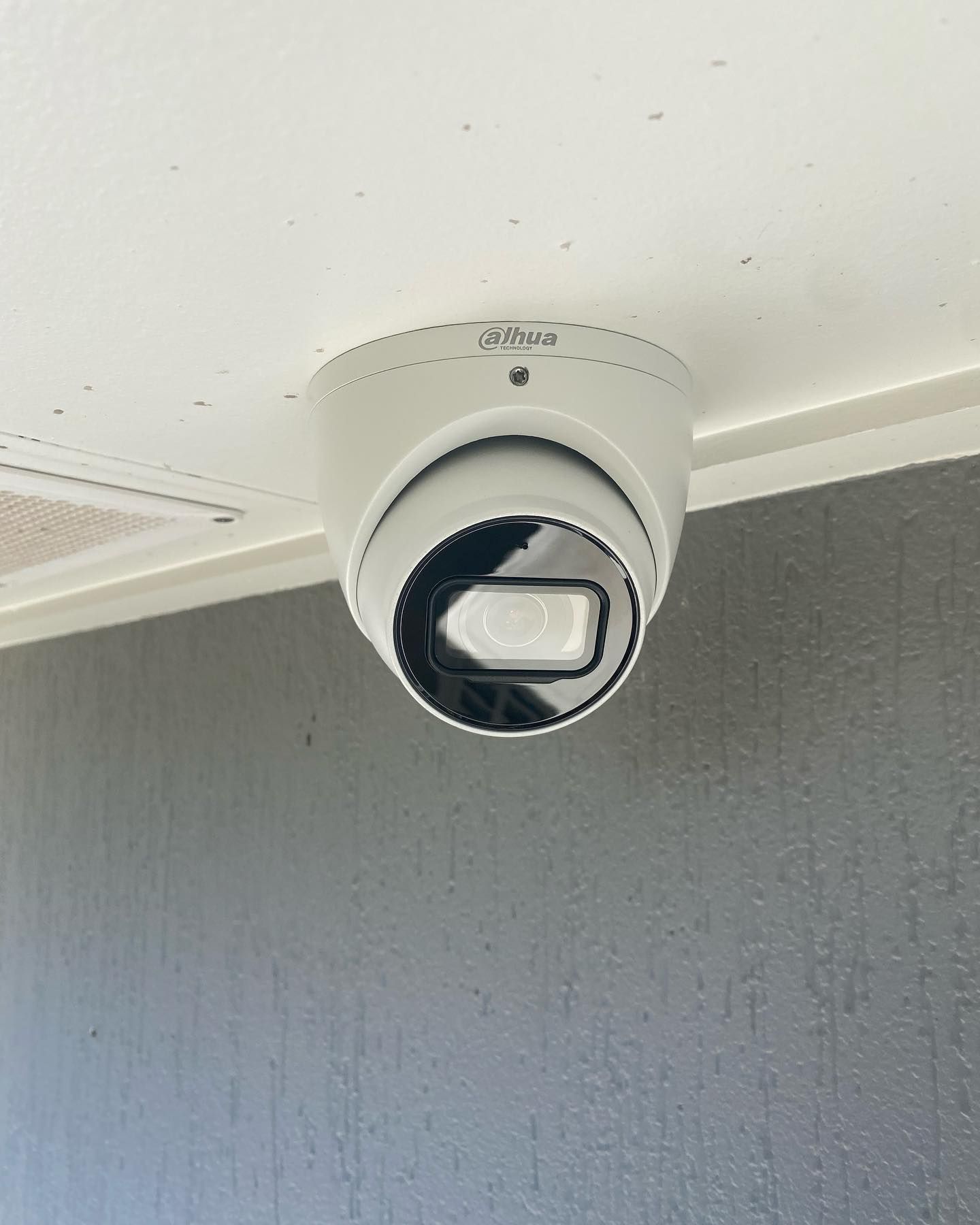 A Security Camera is Mounted to the Ceiling of a Building — DGC Tech Solutions In Mareeba, QLD