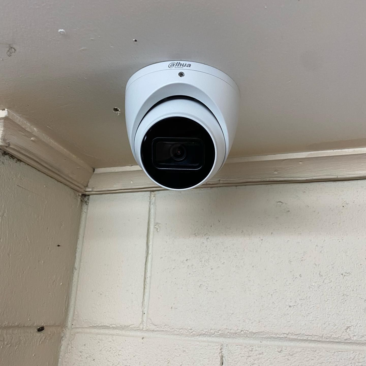 A Security Camera is Mounted on the Ceiling of a Building — DGC Tech Solutions In Mareeba, QLD