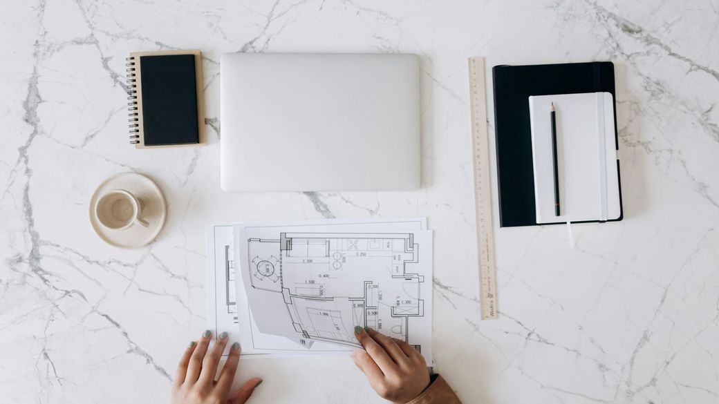 A person is sitting at a table looking at a floor plan.