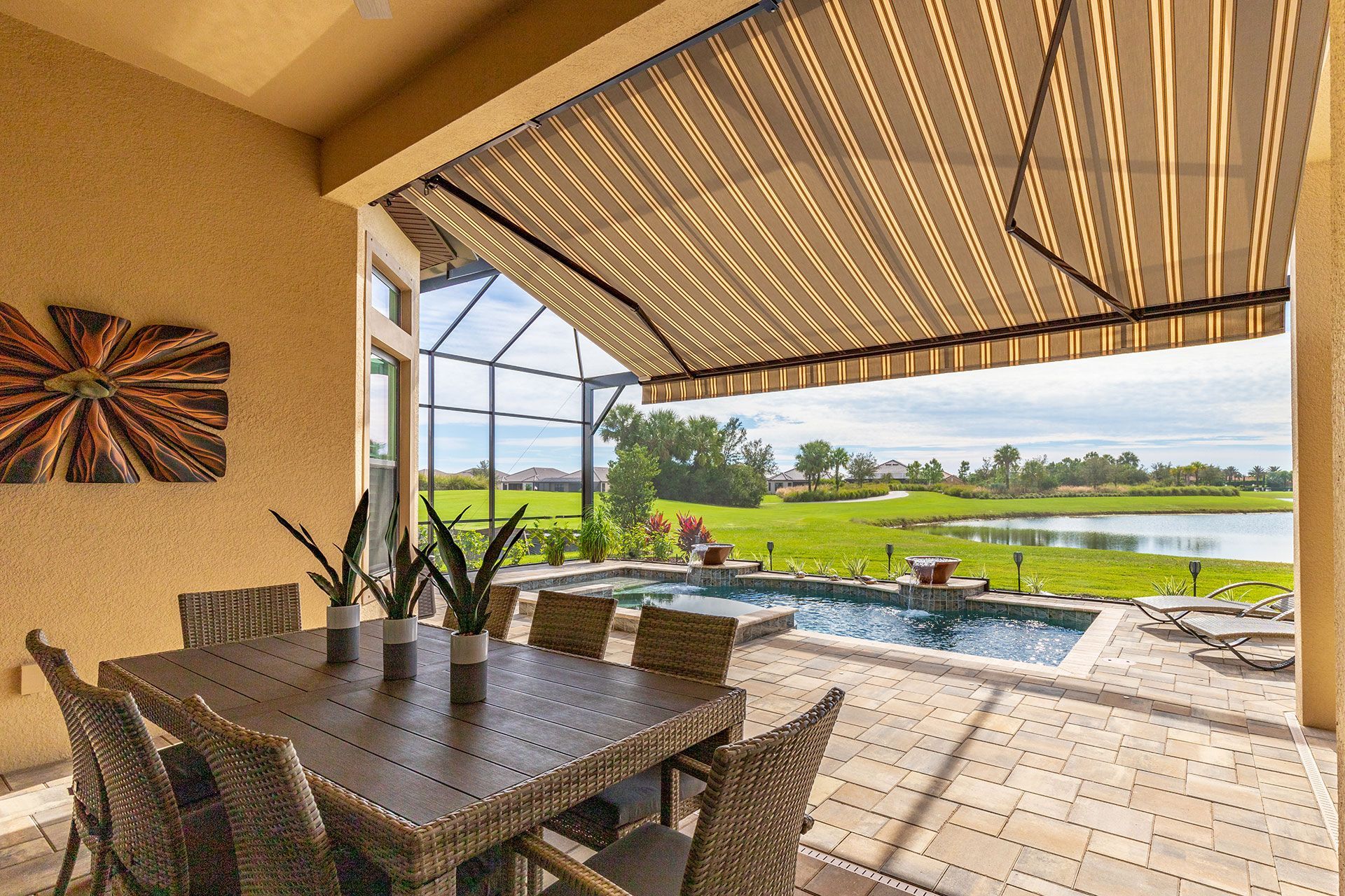 A patio with a table and chairs and an awning over it.