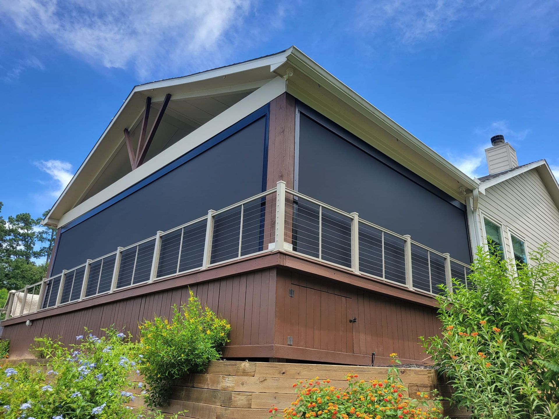 A house with a screened in porch on the side of it.