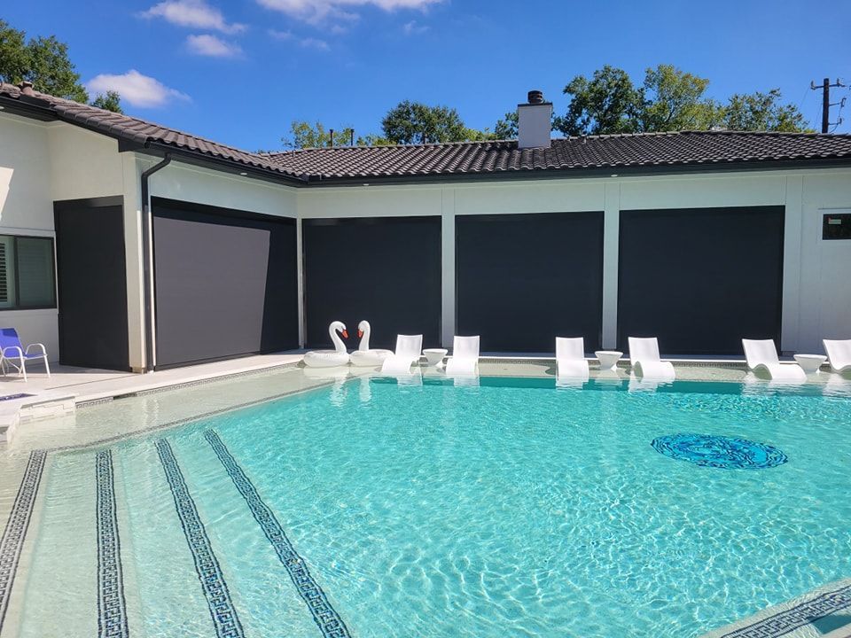 A large swimming pool with a house in the background