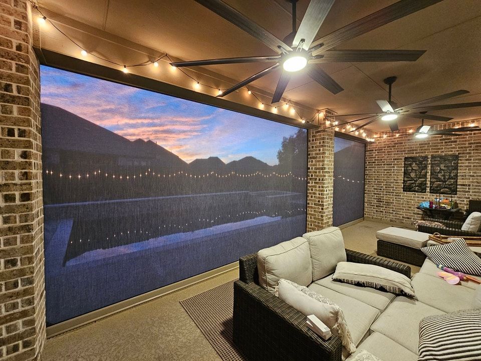 A living room with a couch , chairs and a ceiling fan.