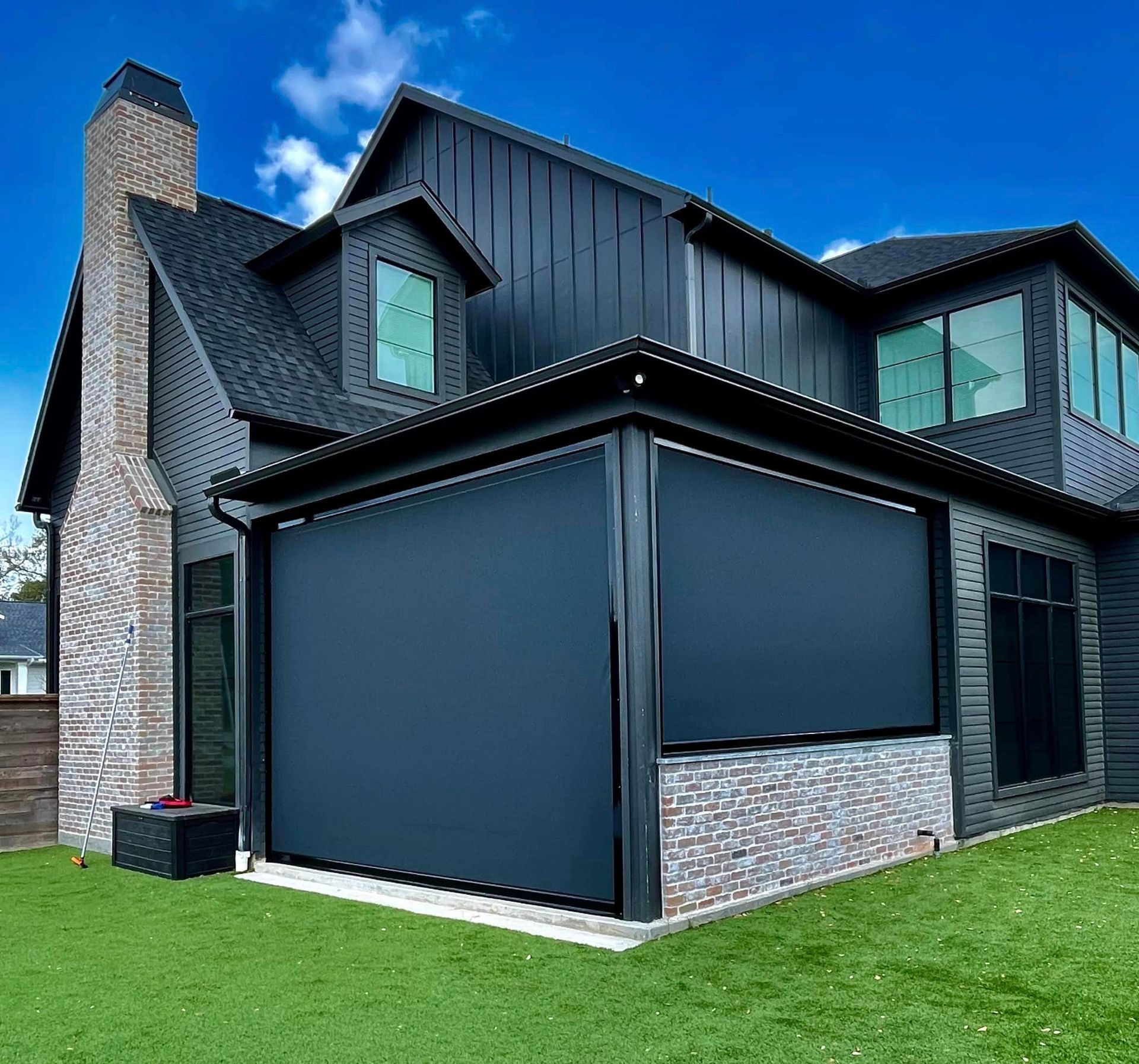 A large black house with a large screen on the side of it.