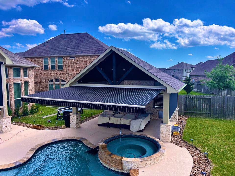 A large house with a swimming pool and an awning over it.