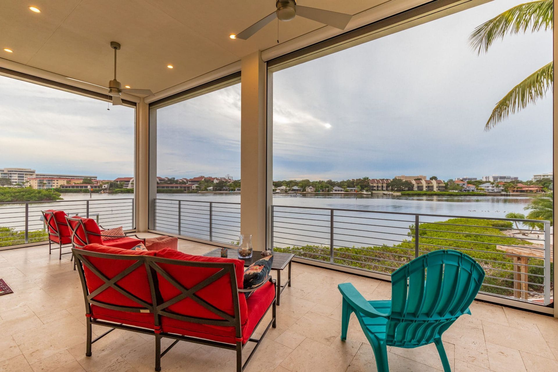 A living room with a couch , chairs and a view of a lake.